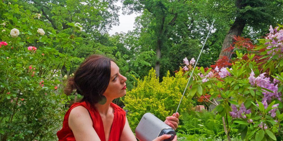 Titelbild zu VERDI:Requiem - eine Frau sitzt im Garten mit einem Radio