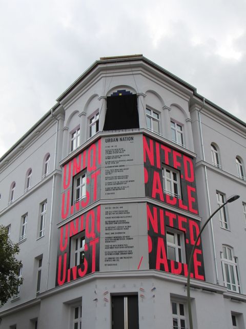 Bildvergrößerung: Altes Eckhaus mit großer roter Schrift