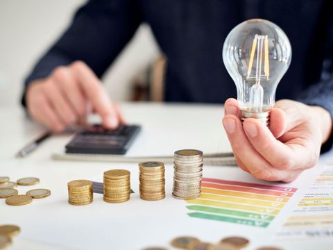 Mann am Schreibtisch macht Berechnungen zum Thema Sparen, Energie, Heizkosten und Umwelt