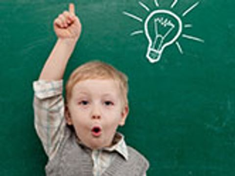 Bildvergrößerung: Kind hebt den Arm vor einer Schultafel auf der eine Glühbirne gezeichnet wurde