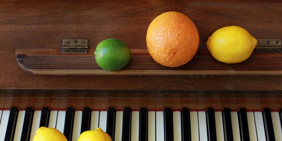 Tastatur eines Klaviers mit Zitrusfrüchten