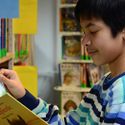 Bildvergrößerung: Junge in der Kinder- und Jugendbibliothek liest