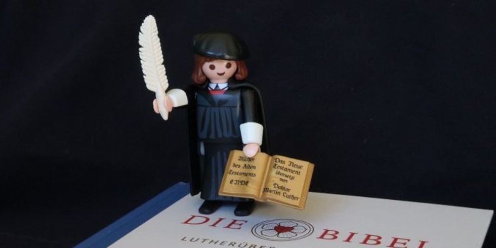 Luther als Symbolfigur stehend auf der Bibel