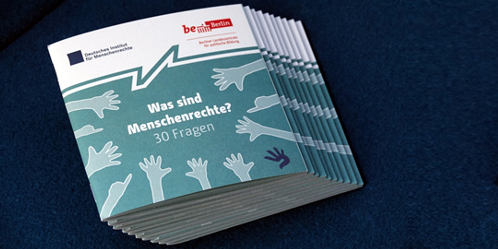 Stapal von Broschüren: Titel "Was sind Menschenrechte? 30 Fragen" umringt von gezeichneten Händen.