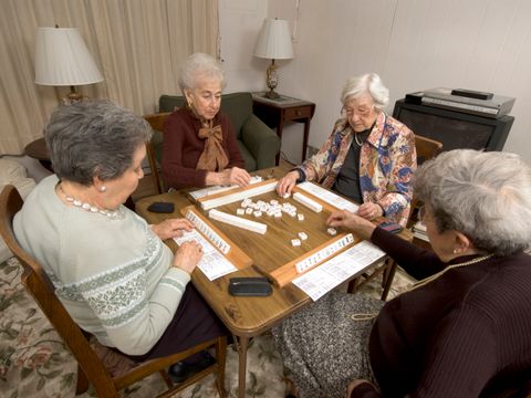vier Seniorinnen spiele Karten am Tisch