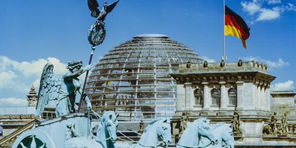 Die Quadriga auf dem Brandenburger Tor, im Hintergrund die begehbare Kuppel des Reichstagsgebäudes