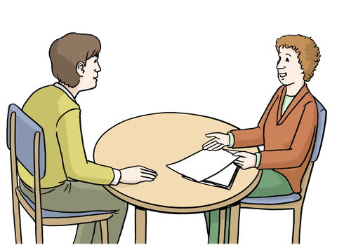 Zwei Personen sitzen am Tisch, eine Person lässt sich von der anderen beraten