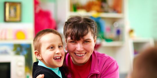 Lächelnder Junge und lächelndes Mädchen mit geistiger Behinderung in einer Rehabilitationseinrichtung
