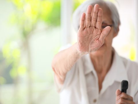 Alte Frau hält Hand hoch Stop zur Gewalt in der Pflege