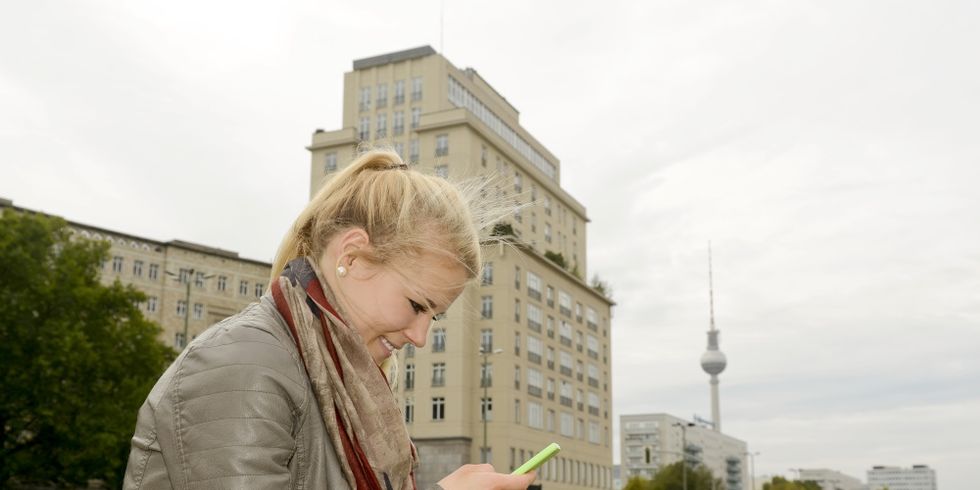 Junge Frau mit Smartphone, Strausberger Platz, Berlin