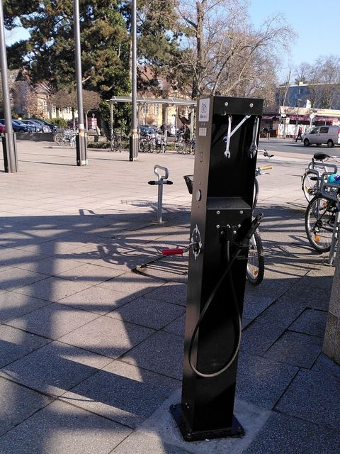Das Bild zeigt eine schwarze Fahrradreparaturstation mit Werkzeugen für kleinere Reparaturen an Fahrrädern
