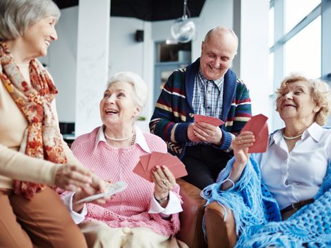 Seniorengruppe, drei Frauen und ein Mann, beim Kartenspielen