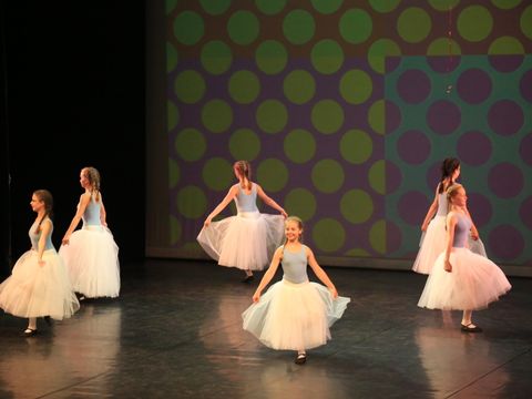 Mädchen im Tütü tanzen auf einer großen Bühne