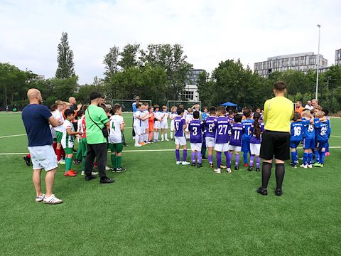 Kinder-Mannschaften trefffen sich in der Spielfeldmitte mit Trainern und Schiedsrichtern