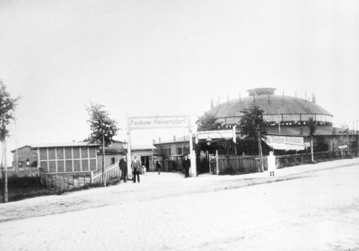 Der Bahnhof Pankow-Heinersdorf mit Lokschuppen und Wirtshaus zur Eisenbahn von August Thüring um 1908.