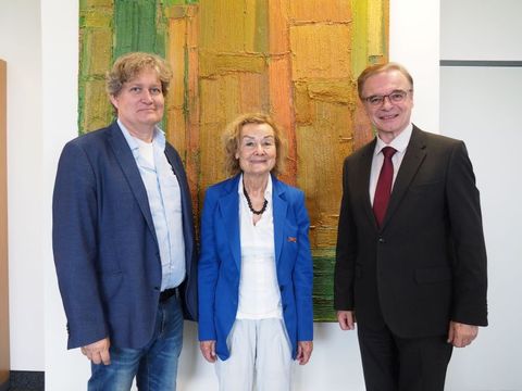 Der Schatzmeister des SoVD Landesverbandes Berlin Brandenburg, Frau Engelen-Kefer und Präsident Allert stehen zusammen vor einem Gemälde. 