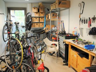 Blick in eine Fahrradwerkstatt mit Fahrrädern, Materialien und Werkzeug