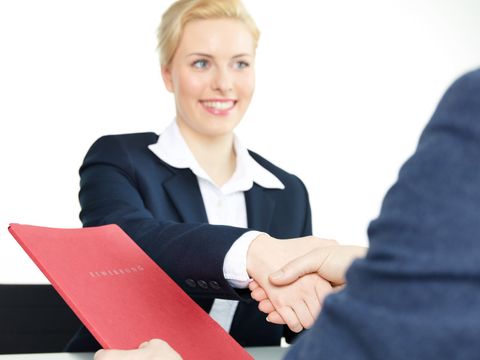 Eine Frau begrüßt einen Kollegen per Handschlag