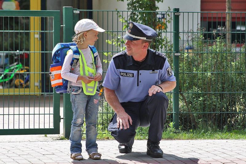 Polizist mit einem Kind am Straßenrand