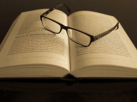 aufgeschlagenes Buch mit Brille