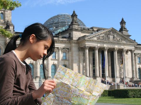 Mädchen mit Stadtplan vor dem Reichstagsgebäude