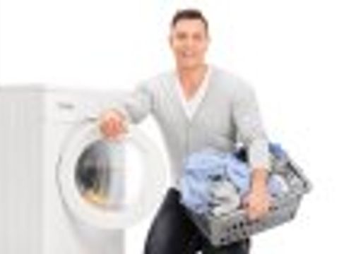  Junger Mann mit Wäschekorb vor Waschmaschine