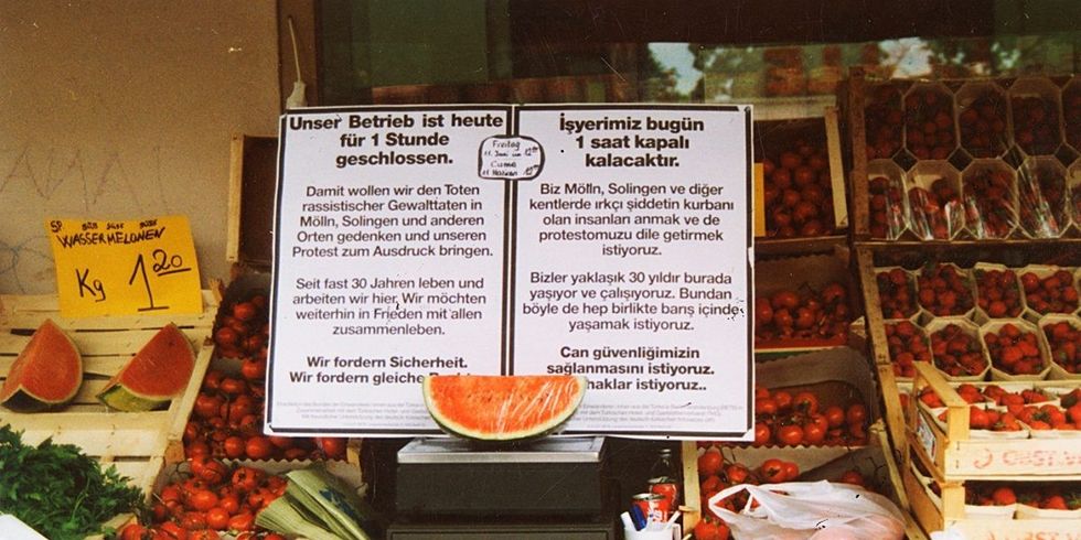 Obststand mit einer in türkisch und deutsch beschriebenen Tafel davor