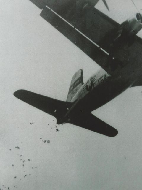 Ein Flugzeug wirft kleine Fallschirme ab