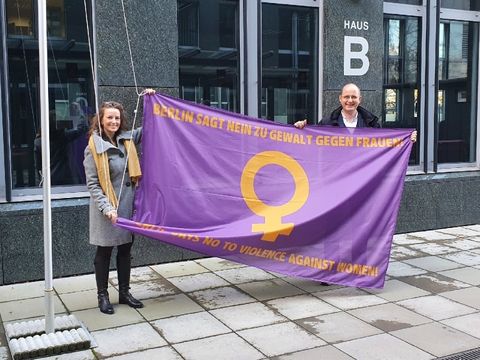 LAF Präsident Straßmeir und Frauenvertreterin Nürnbach hissen die Berliner Anti-Gewalt-Flagge
