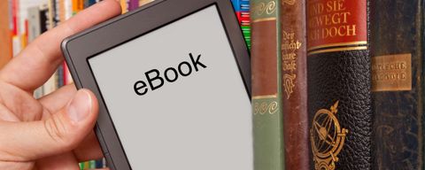 eBook vs Buch, e-Reader aus einem Bücherregal ziehen
