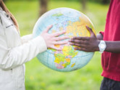 Zwei junge Leute halten einen Globus