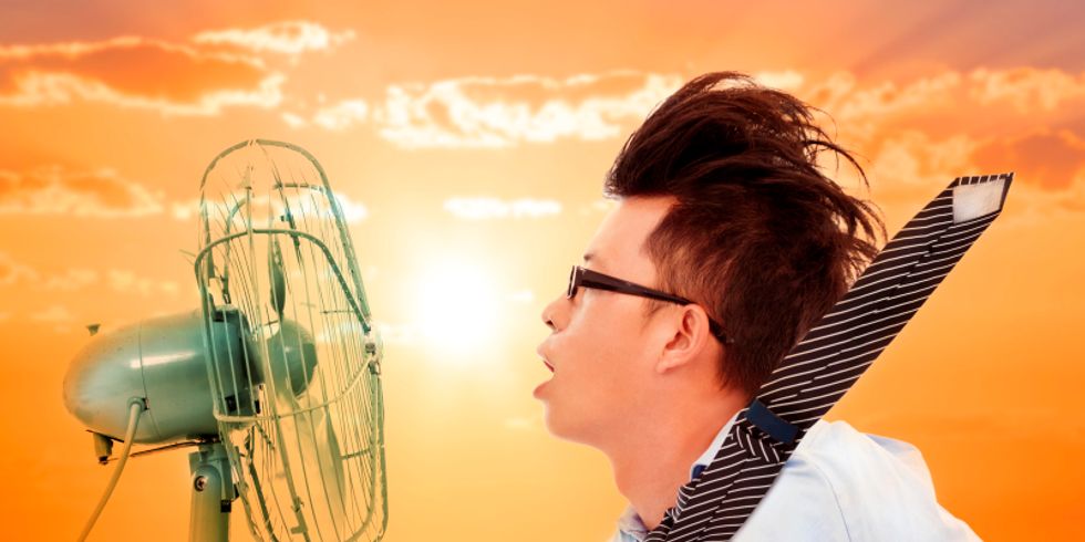 ein junger Mann kült sich vor einem Ventilator ab