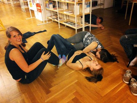 Bildvergrößerung: Jugendliche liegen auf dem Fussboden der Bibliothek
