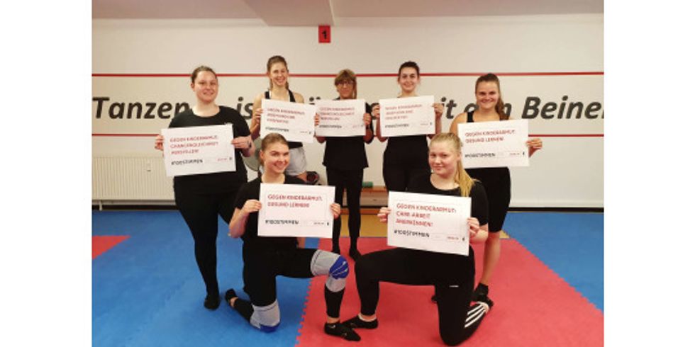 Tänzerinnen der Berliner Funken mit Slogans der Kampagne #100Stimmen