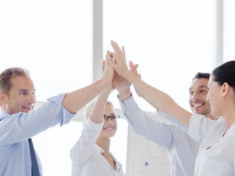 happy business team giving high five in of