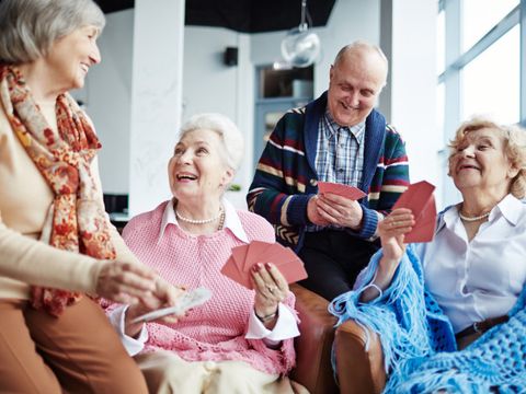 Seniorengruppe, drei Frauen und ein Mann, beim Kartenspielen