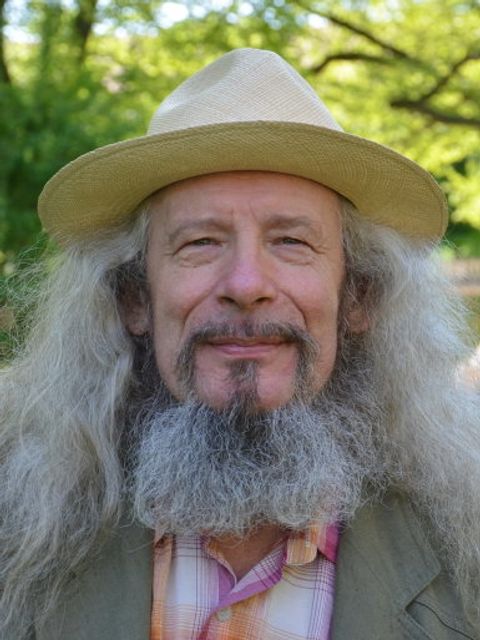 Portrait-Foto eines Mannes mit Hut und Bart in einem Park
