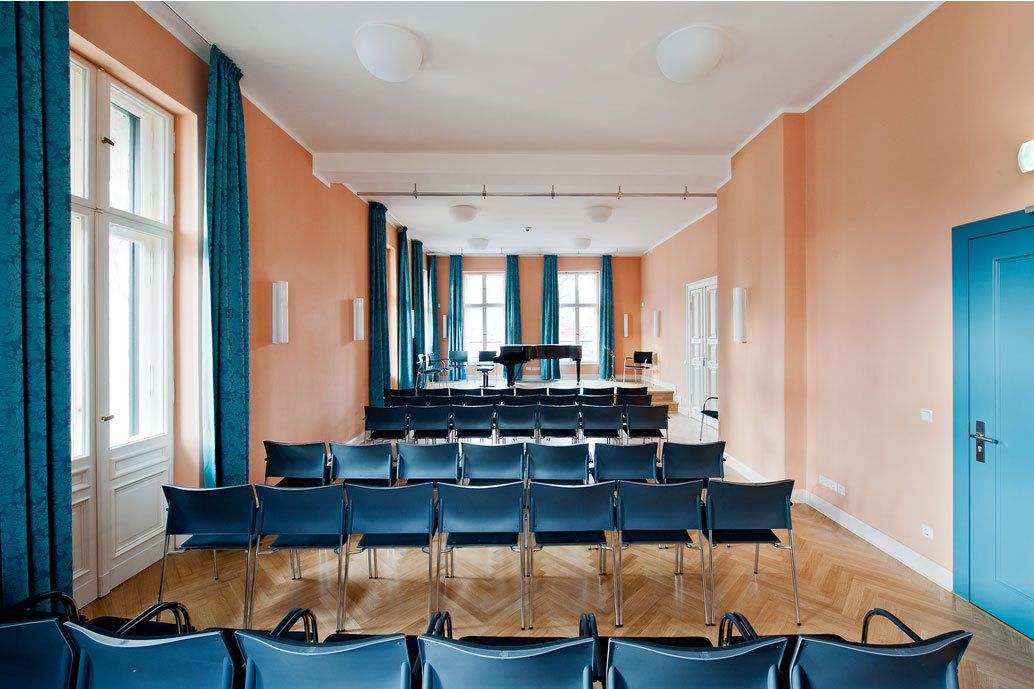 Blick durch den Konzertsaal der Leo-Borchard-Musikschule: im Vordergrund Stuhlreihen, im Hintergrund der Flügel auf der Bühne