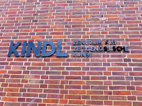 Schriftzurg des KINDL-Zentrum in schwarzen einzelnen Buchstaben auf einer roten Backsteinwand. 