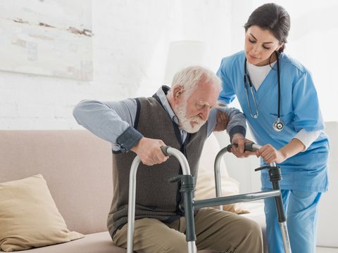 Arzt hilft Rentner beim Aufstehen
