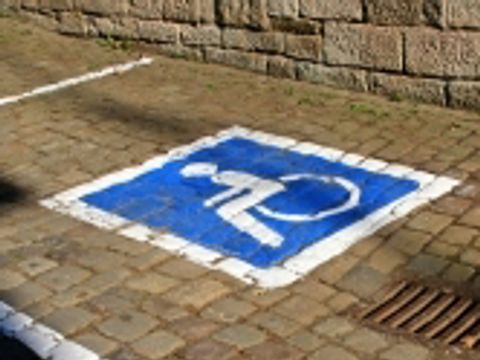 Ein Parkplatz für Behinderte mit Kennzeichnung auf einer Pflastersteinstraße