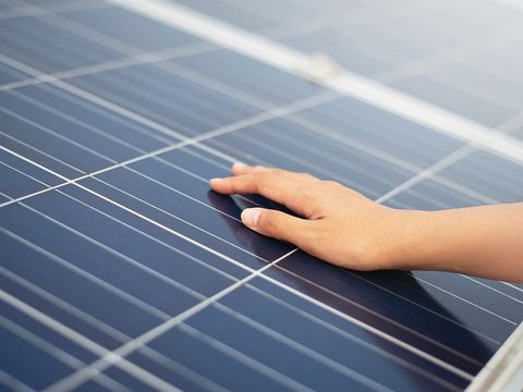 Hand auf Solarpanel