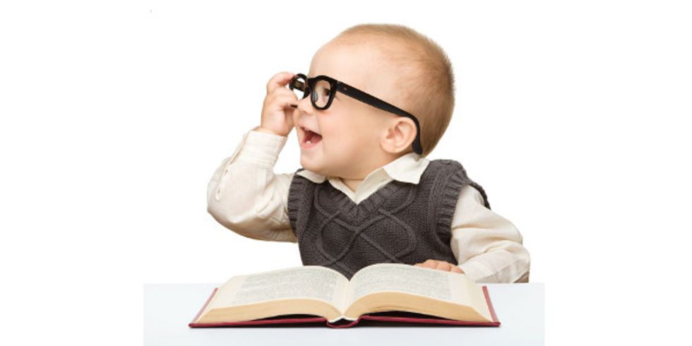Little child play with book and glasses