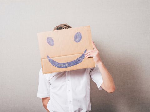Mann hält einen Karton mit einem Smiley