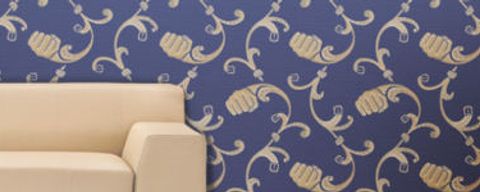 Beiges Sofa mit blauer Tapete die ein Muster aus Fäusten zeigt