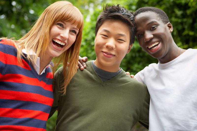 Drei lachende Jugendliche unterschiedlicher Ethnien