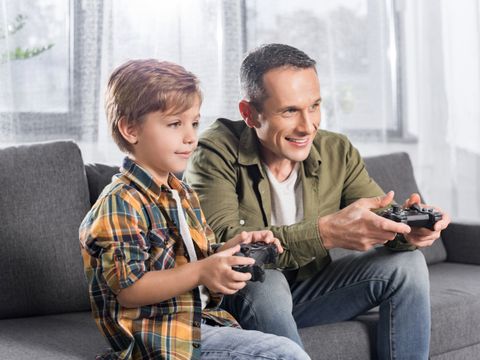 ein Mann und ein Kind spielen gemeinsam ein Computerspiel