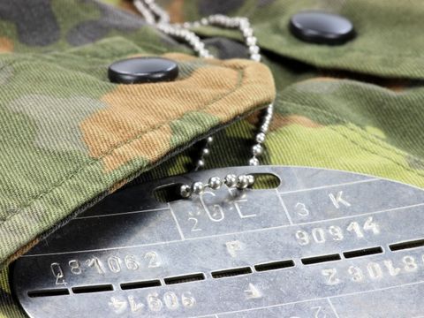 Erkennungsmarke aus Blech liegt auf einer Uniform der Bundeswehr