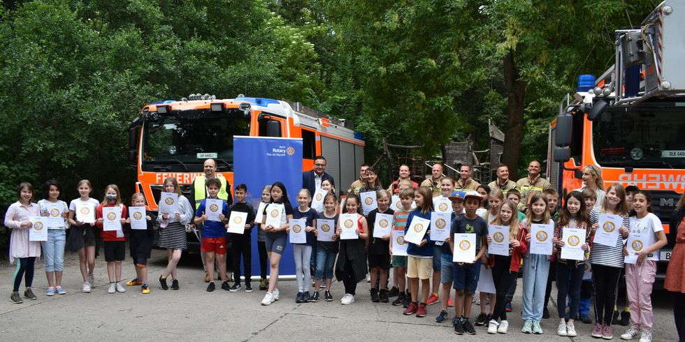 Kinder der Grundschule im Gutspark mit Bezirksbuergermeister und Feuerwehrkraeften