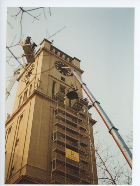 Enlarge photo: A bell is lifted out of a bellfry by a crane.